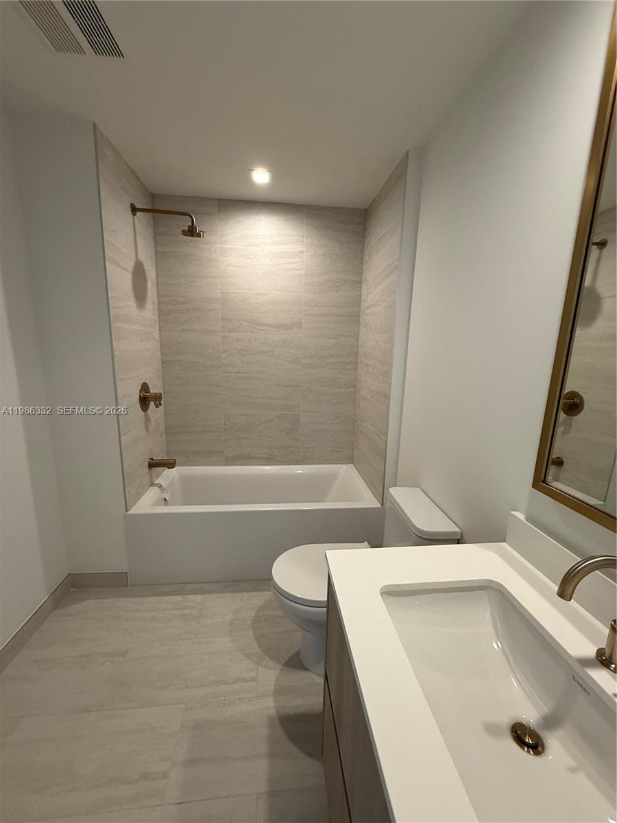 An empty room with light-colored tile flooring, white walls, and a large balcony window — 77 SE 5 St # 2015, Miami FL 33131, MIAMI, FL