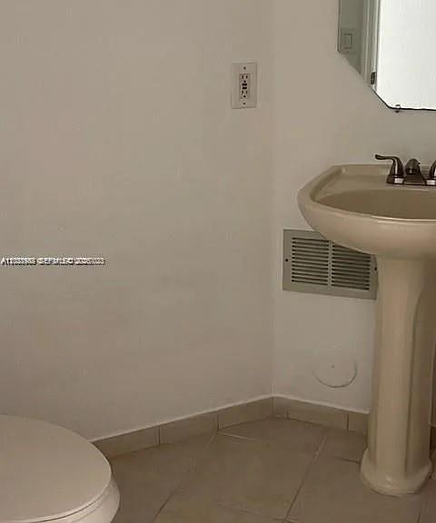A bathroom features a pedestal sink, a toilet, a wall vent, and a mirror — 7778 NW 116th Ave # 0, Doral FL 33178, DORAL, FL
