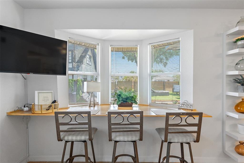 A breakfast nook features a wooden counter, three bar stools, and a bay window — 2810 2ND AVENUE S UNIT B, ST PETERSBURG, FL