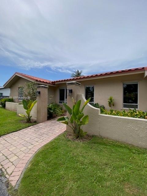 A single-story house with a red tile roof and a paved walkway leading to the entrance — 9760 SW 128th St, Miami FL 33176, MIAMI, FL
