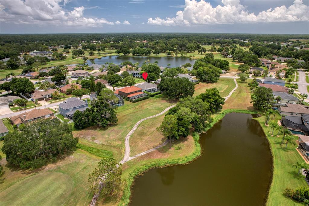 An aerial view shows a residential neighborhood with houses, a golf course, and two ponds — 16215 HOYLAKE DRIVE, ODESSA, FL