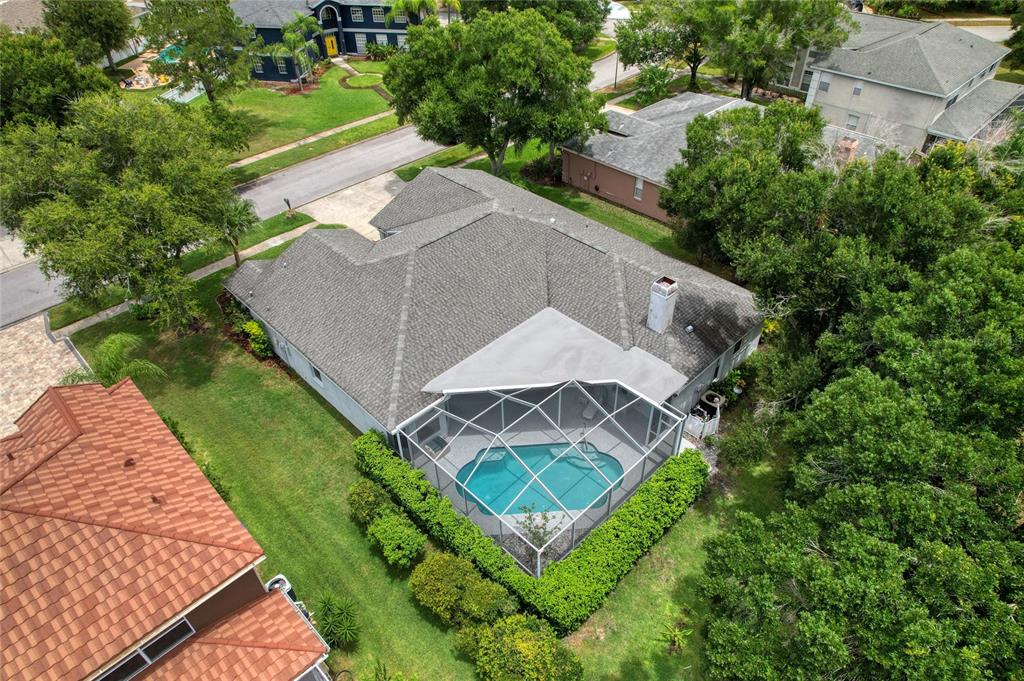An aerial view shows a house with a gray roof and a screened-in swimming pool — 16215 HOYLAKE DRIVE, ODESSA, FL