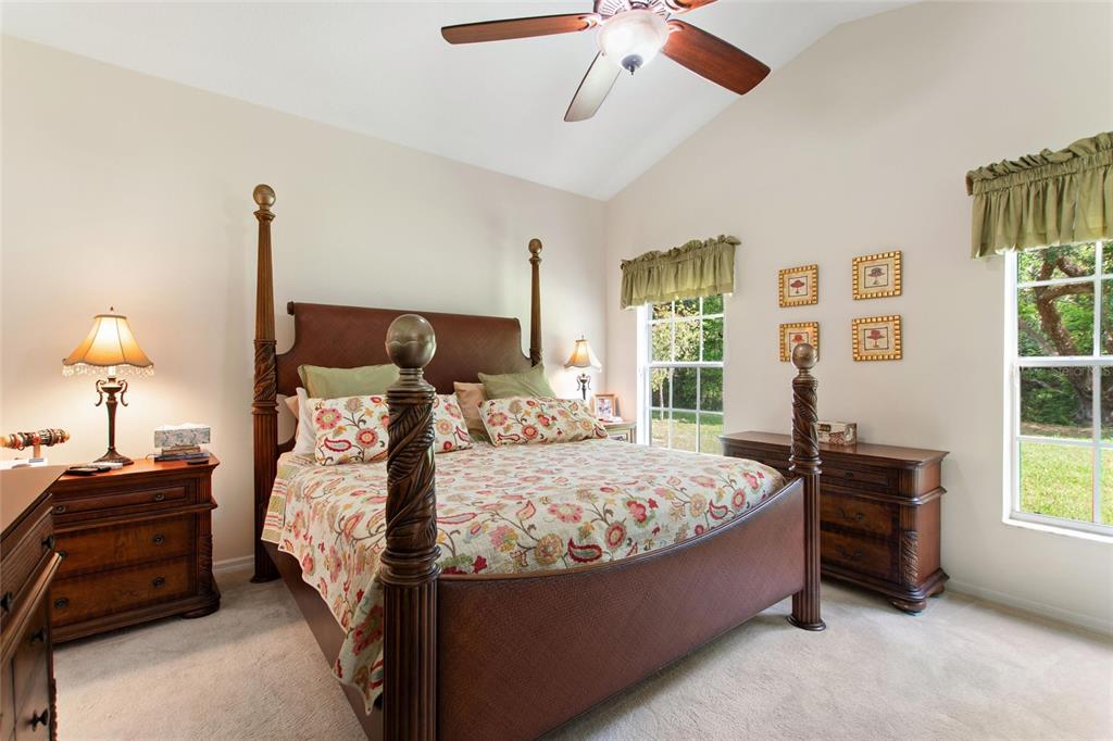 A bedroom features a four-poster wooden bed, two nightstands, and windows with green valances — 612 VISTA OAKS WAY, DAVENPORT, FL