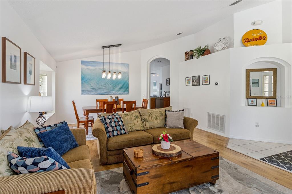 A living room with a brown sofa, wooden coffee table, and an adjacent dining area — 3062 BARBADOS LANE, HAINES CITY, FL