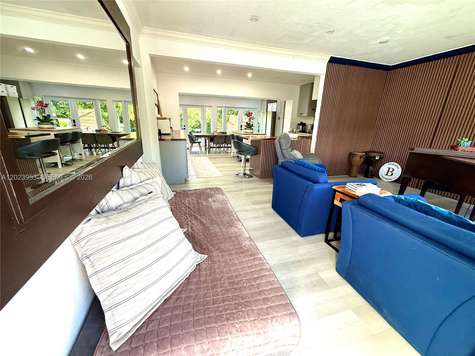 A living room features blue armchairs, a daybed, and a view into the kitchen — 3280 SW 16th Ter, Miami FL 33145, MIAMI, FL