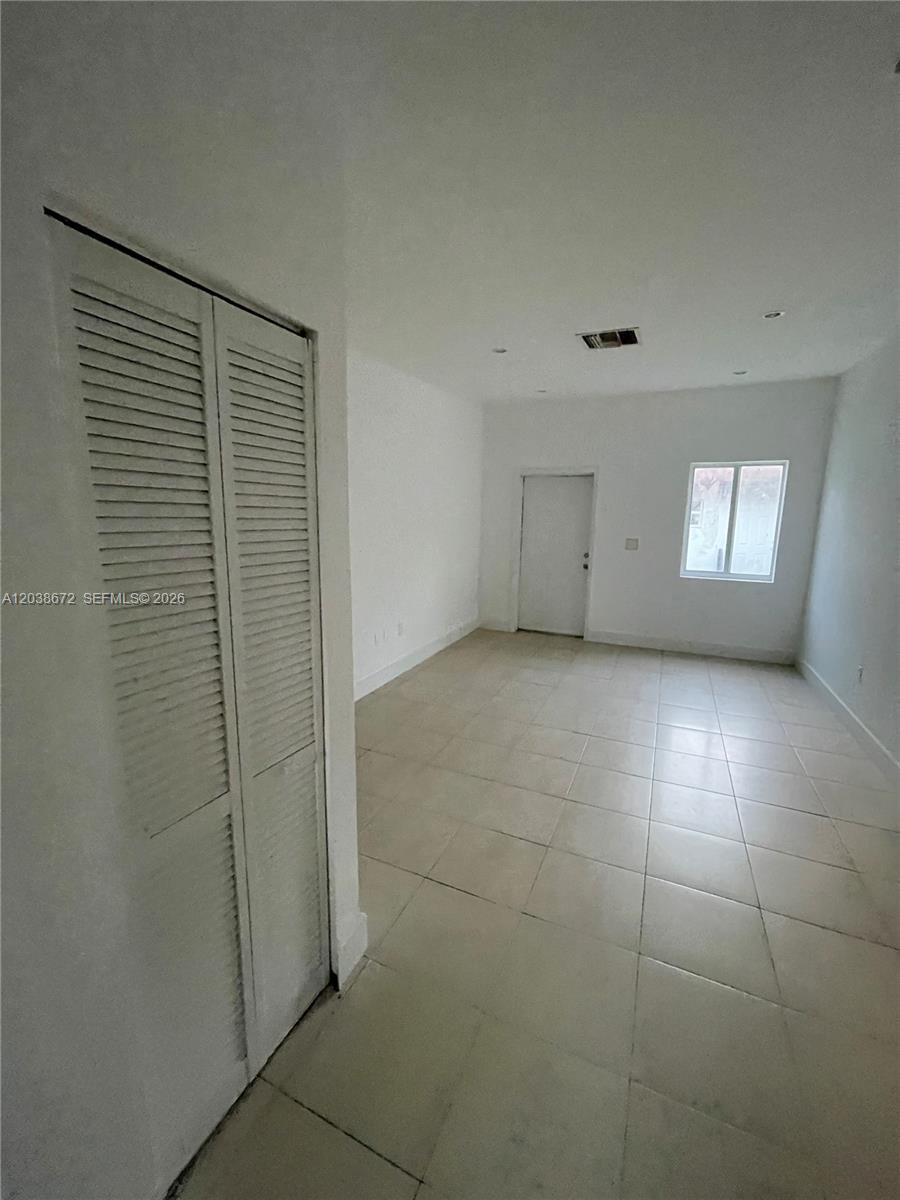 This room features white walls, light-colored tile flooring, a louvered closet door, and a window — 4729 NW 15th Ave # 4727, Miami FL 33142, MIAMI, FL