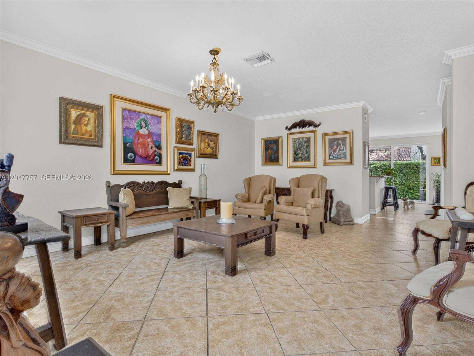 A living room features tile flooring, a wooden coffee table, armchairs, and a gallery wall — 18843 SW 26th St, Miramar FL 33029, MIRAMAR, FL