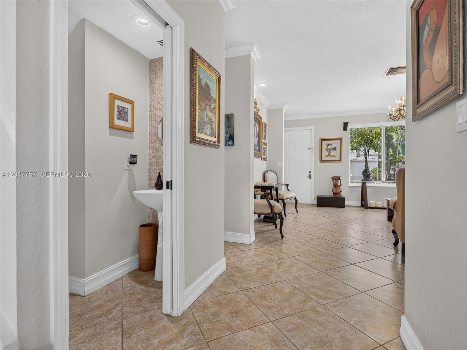 A tiled hallway leads to a powder room and an open living area with windows — 18843 SW 26th St, Miramar FL 33029, MIRAMAR, FL