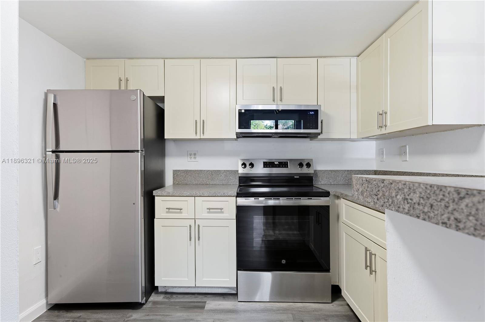 A kitchen features stainless steel appliances, light-colored cabinets, and speckled granite countertops — 9877 Nob Hill Ct # 9877, Sunrise FL 33351, SUNRISE, FL