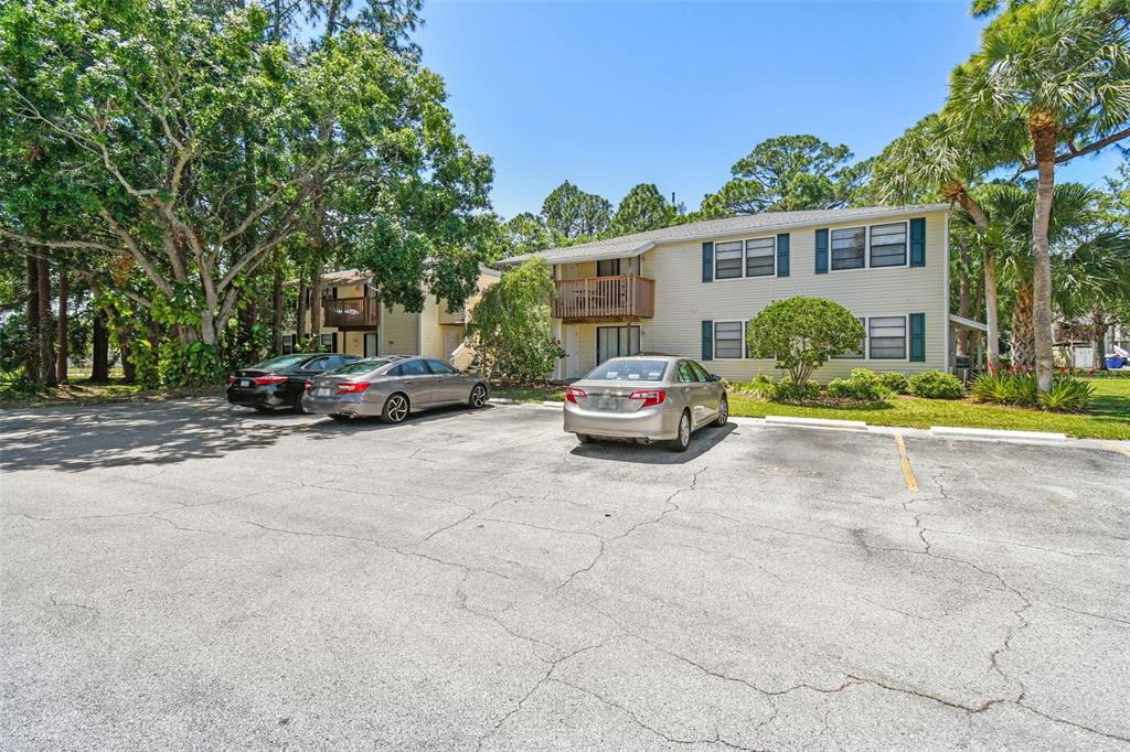 A two-story apartment building with beige siding and a parking lot in front — 134 SYCAMORE LANE UNIT H, OLDSMAR, FL