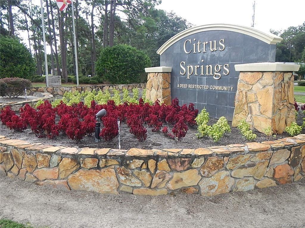 A stone monument sign for Citrus Springs stands in a landscaped garden bed — 8791 N FOLLAND DRIVE, DUNNELLON, FL