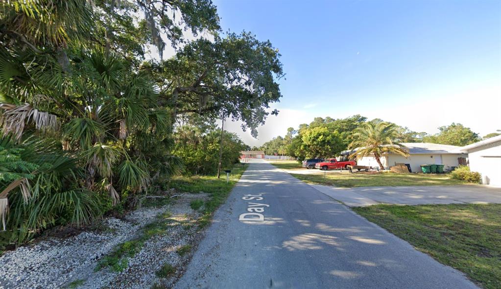 A paved street named Day St runs between a wooded area and residential properties — 4250 DAY STREET, PORT CHARLOTTE, FL