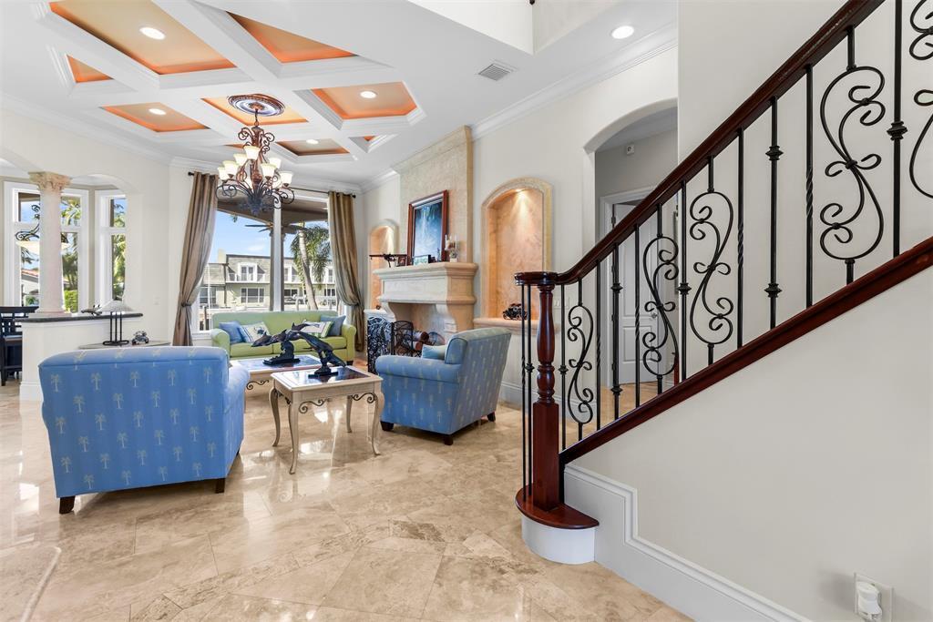 A living room features a coffered ceiling, stone fireplace, tile flooring, and a decorative staircase — 4431 NE 24th Avenue, Lighthouse Point FL 33064, LIGHTHOUSE POINT, FL