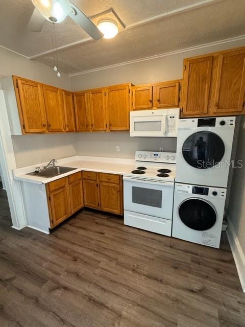 A kitchen features wood cabinets, a sink, a stove, and a stacked washer and dryer — 910 S PARK AVENUE UNIT A, SANFORD, FL