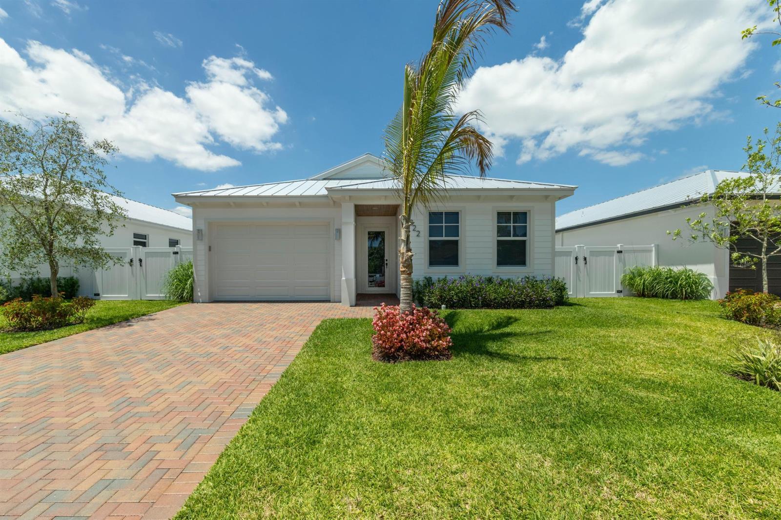 A single-story white house with a metal roof, brick driveway, and a palm tree — 1022 Miami Boulevard, Delray Beach FL 33483, DELRAY BEACH, FL