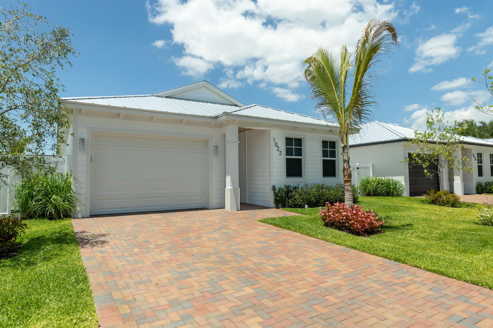 A single-story white house with a metal roof, brick driveway, and a palm tree — 1022 Miami Boulevard, Delray Beach FL 33483, DELRAY BEACH, FL