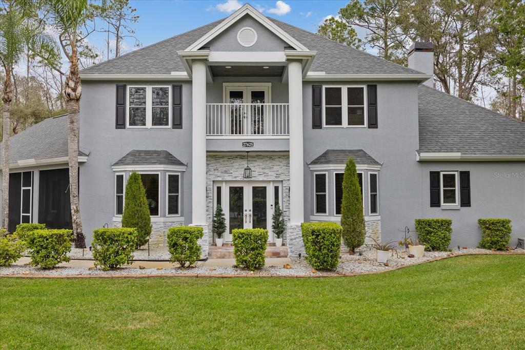 A two-story gray house with a white fountain in the front yard — 27625 LINCOLN PLACE, WESLEY CHAPEL, FL