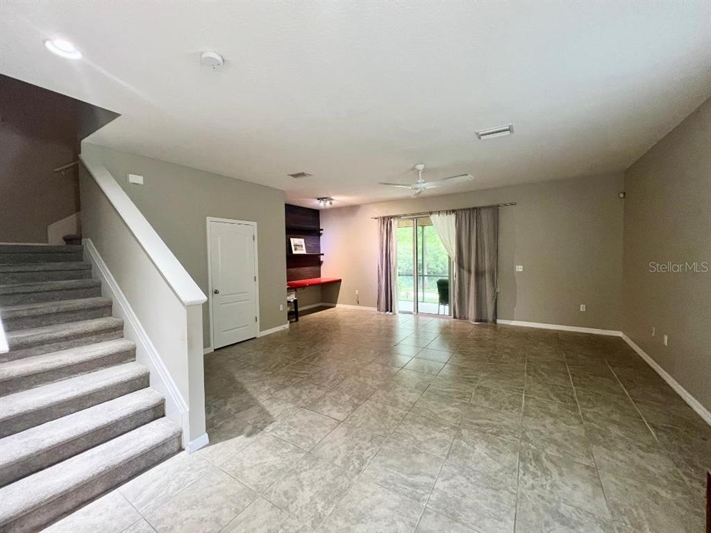 A living area features tile flooring, a carpeted staircase, and a built-in desk nook — 13801 RIVER FISH CT, TAMPA, FL