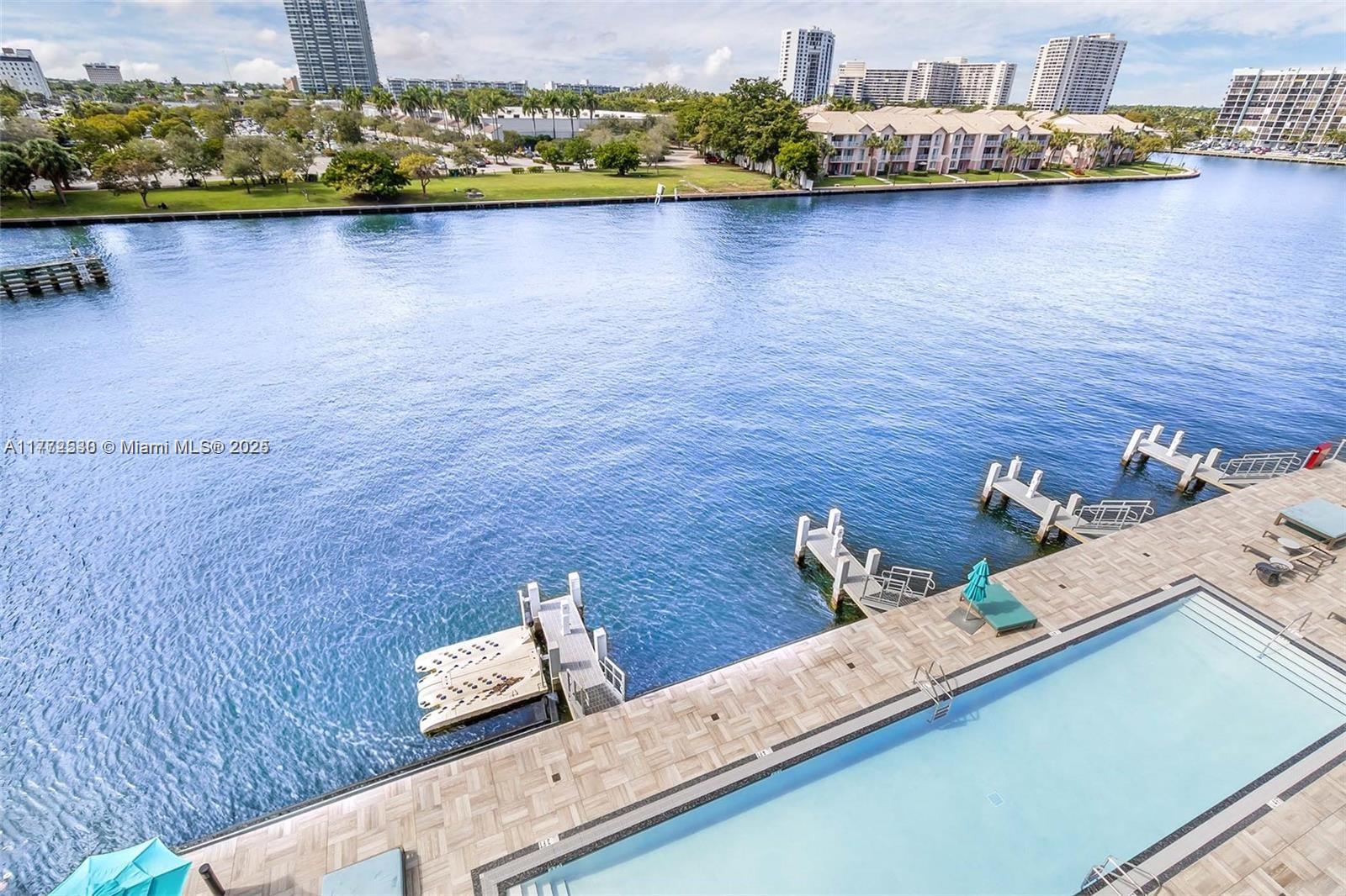 An elevated view shows a swimming pool deck overlooking a canal with several boat docks — 4010 S Ocean Dr # R406, Hollywood FL 33019, HOLLYWOOD, FL
