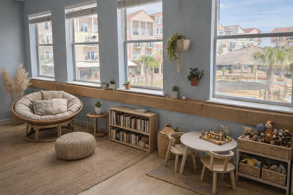 A sunlit playroom features a papasan chair, a small table with chairs, and large windows — 101 PALM HARBOR PARKWAY UNIT OC2, PALM COAST, FL