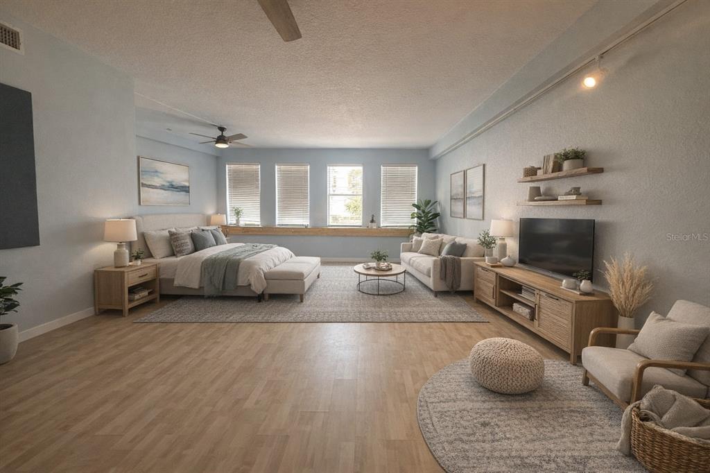 This is a spacious studio apartment featuring a bedroom area, living space, and wood flooring — 101 PALM HARBOR PARKWAY UNIT OC2, PALM COAST, FL