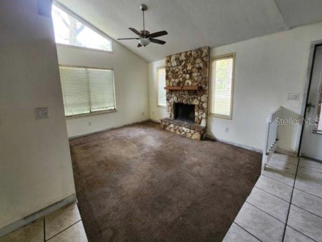 A living room features a stone fireplace, brown carpeting, a ceiling fan, and large windows — 270 AMBERWOOD COURT, ORMOND BEACH, FL
