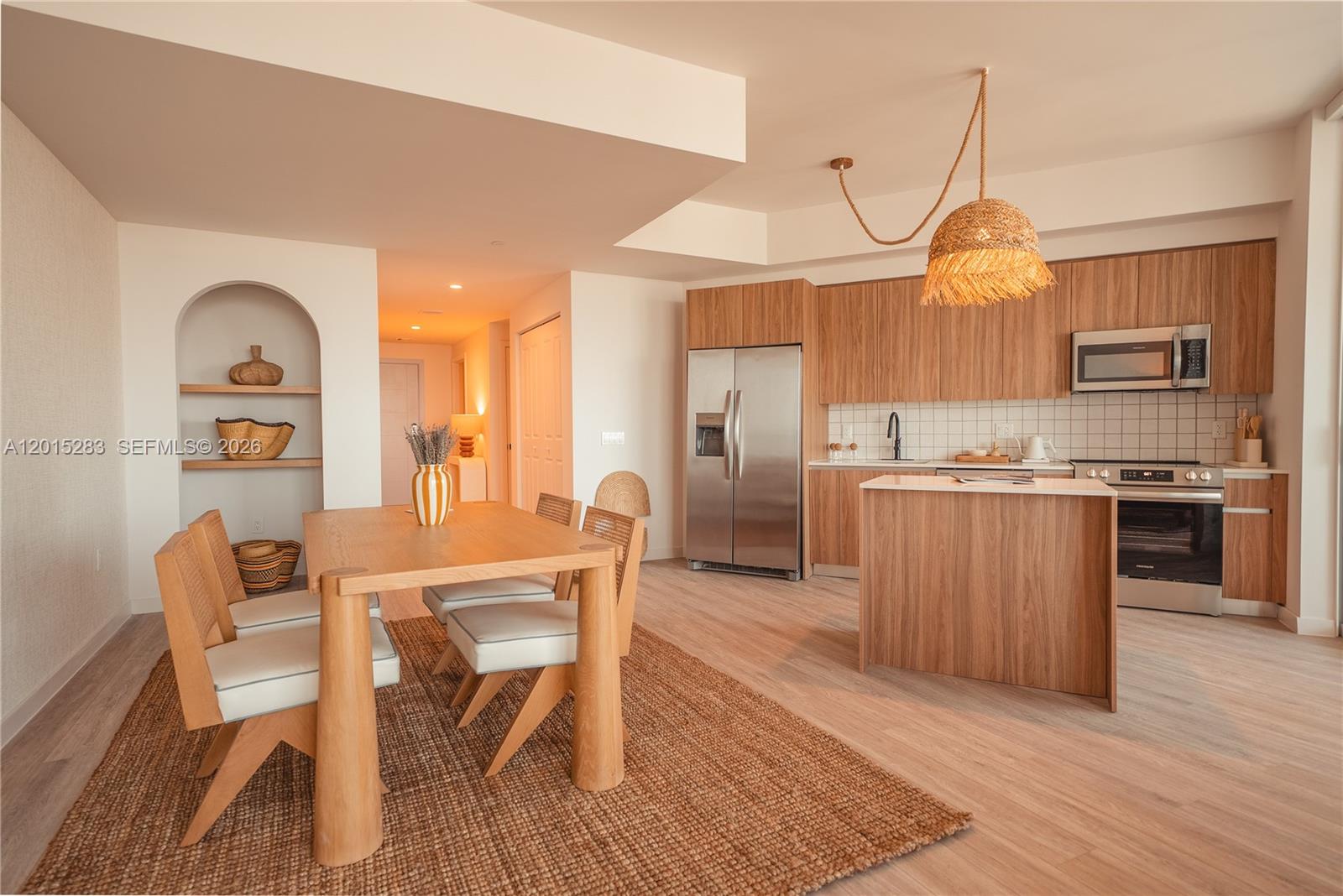 A dining area with a wooden table and chairs sits adjacent to a modern kitchen — 275 SW 6th St # 5308, Miami FL 33130, MIAMI, FL