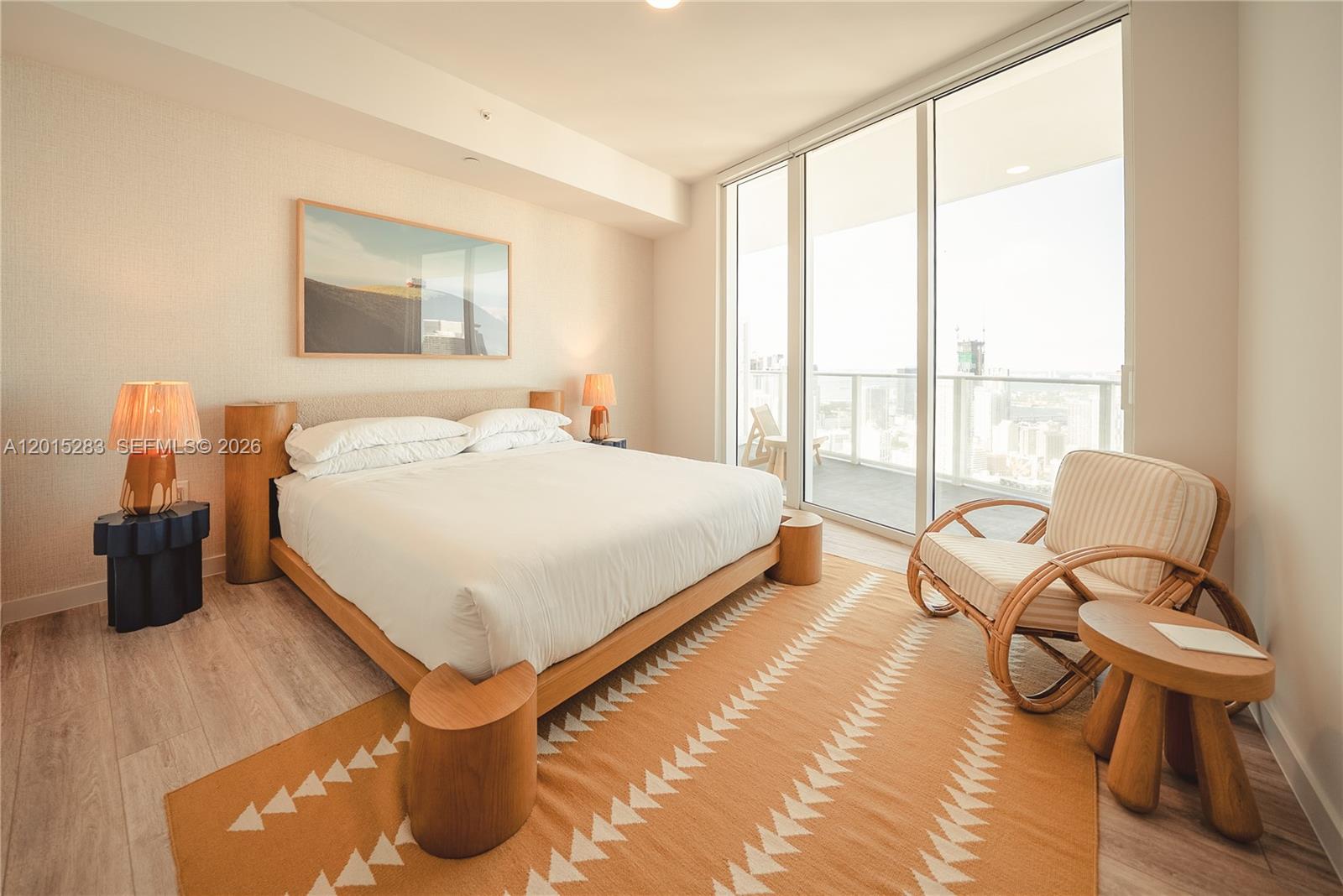 A bedroom features a platform bed, a patterned rug, and a balcony with city views — 275 SW 6th St # 5308, Miami FL 33130, MIAMI, FL