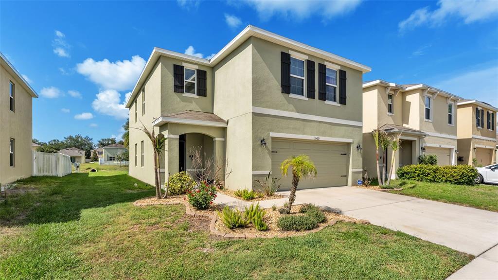 A two-story, light green suburban house with a two-car garage and a concrete driveway — 3509 DIAMOND LEAF COURT, VALRICO, FL