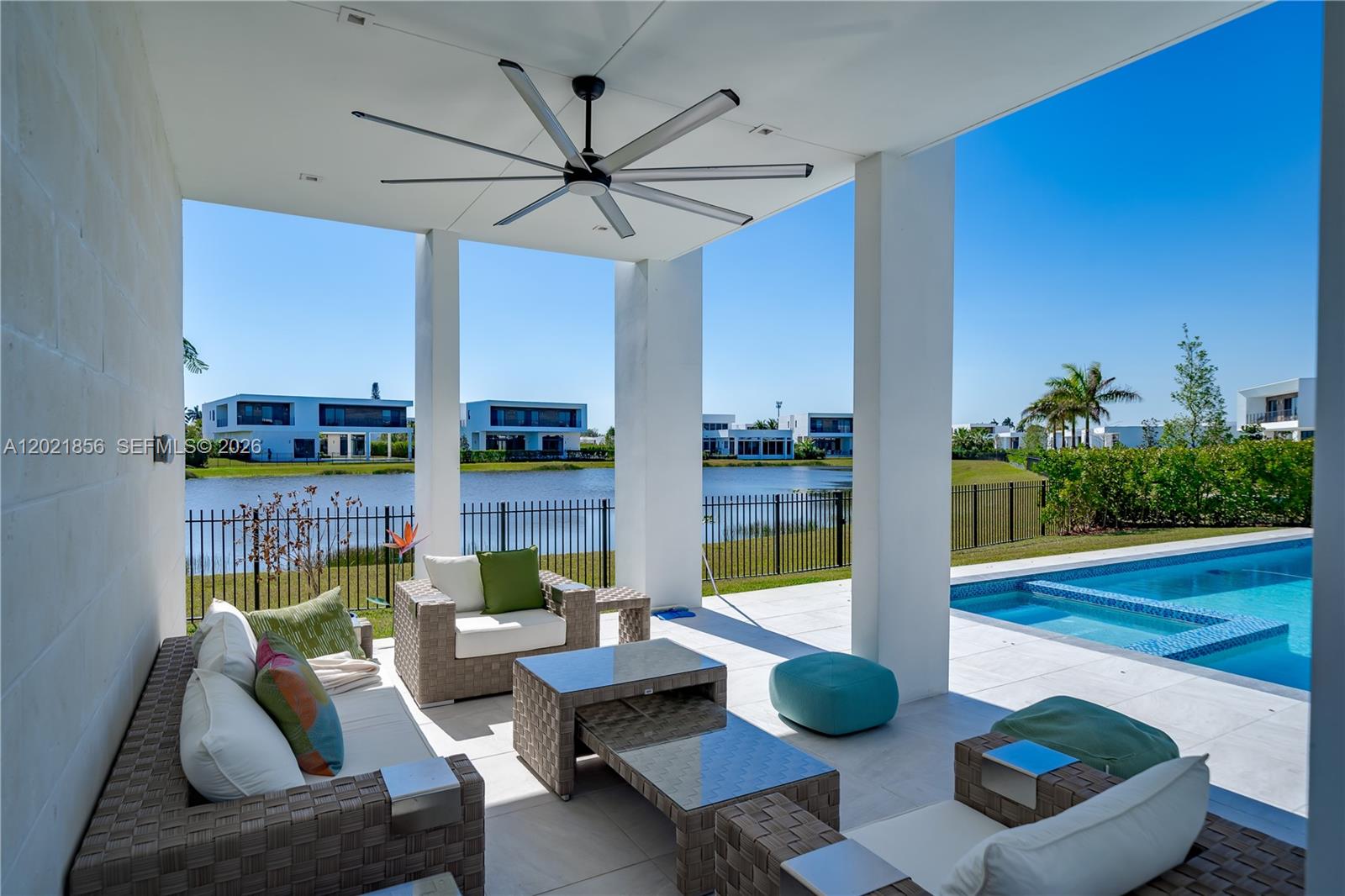 A covered patio features outdoor furniture, a large ceiling fan, and a view of a pool — 16600 Sunset Way, Weston FL 33326, WESTON, FL