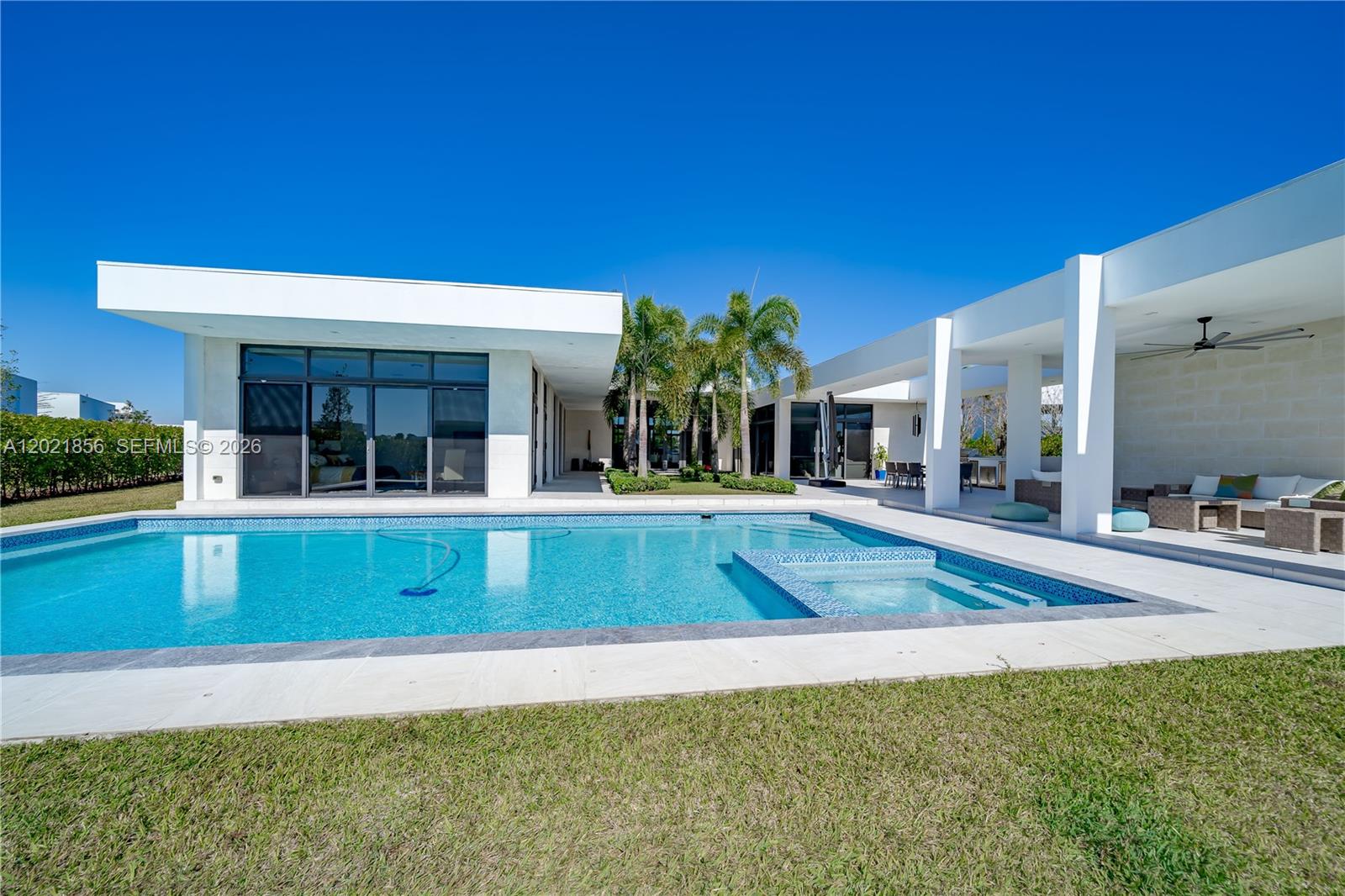 A modern white house features a swimming pool with an integrated spa and patio area — 16600 Sunset Way, Weston FL 33326, WESTON, FL
