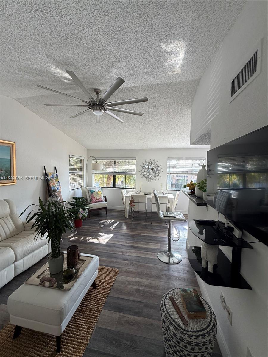 A living room features a white sofa, a dining area, and a ceiling fan — 10670 SW 156th Pl # 308, Miami FL 33196, MIAMI, FL