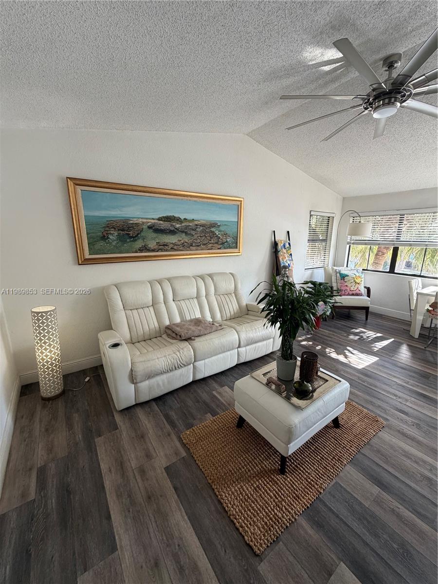 A living room features a white leather sofa, a matching ottoman, and wood-look flooring — 10670 SW 156th Pl # 308, Miami FL 33196, MIAMI, FL