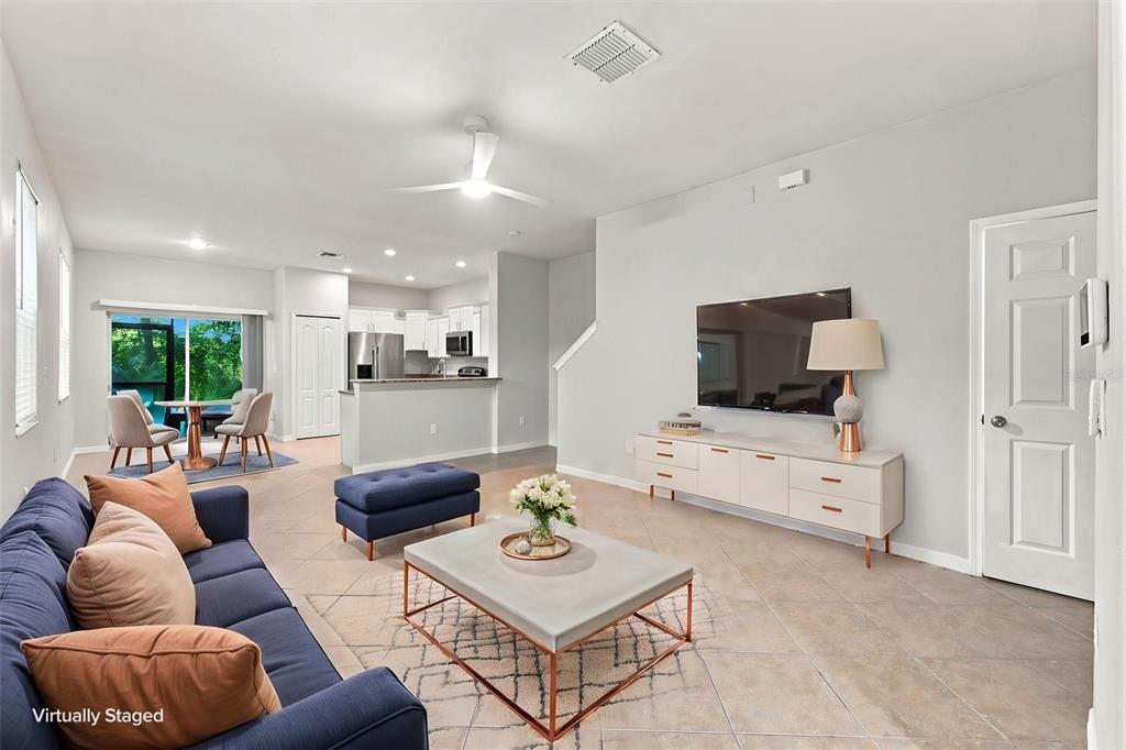 A living room with tile floors, a blue sofa, and an open kitchen in the background — 2837 SANTEGO BAY COURT, BRANDON, FL