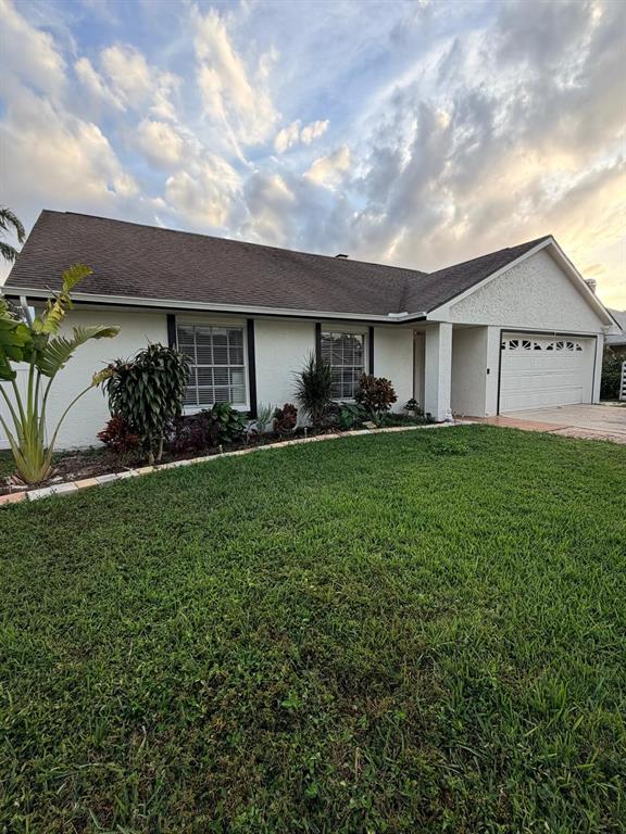 A single-story house with a white stucco exterior, dark roof, and an attached two-car garage — 15126 NIGHTHAWK DRIVE, TAMPA, FL
