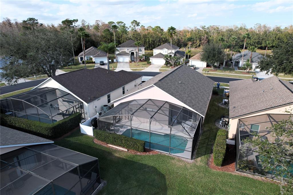 An aerial view shows several suburban houses with screened-in swimming pools and backyard landscaping — 1068 LAKE BERKLEY DRIVE, KISSIMMEE, FL