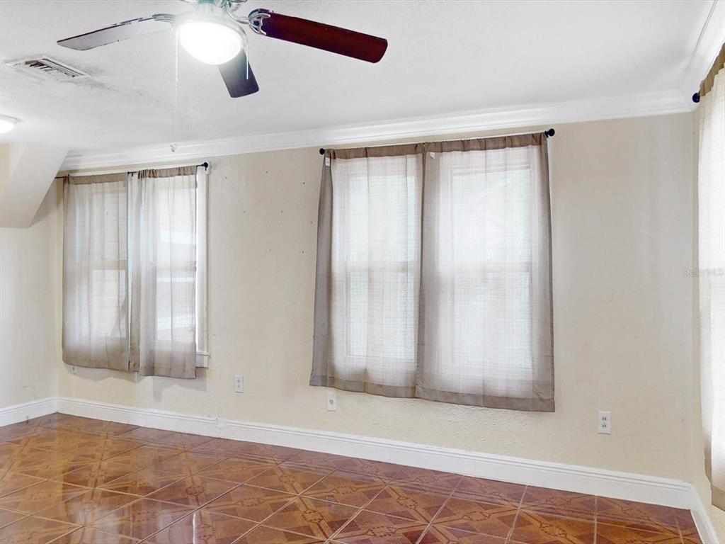 A room with tiled floors, a ceiling fan, and two windows covered by sheer curtains — 2017 MILLER BOULEVARD, FRUITLAND PARK, FL
