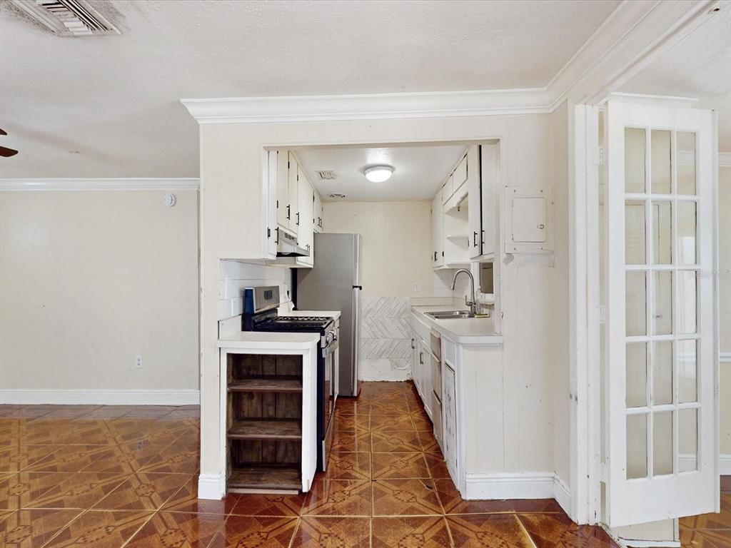 A kitchen with white cabinets, a stainless steel refrigerator, and patterned tile flooring — 2017 MILLER BOULEVARD, FRUITLAND PARK, FL