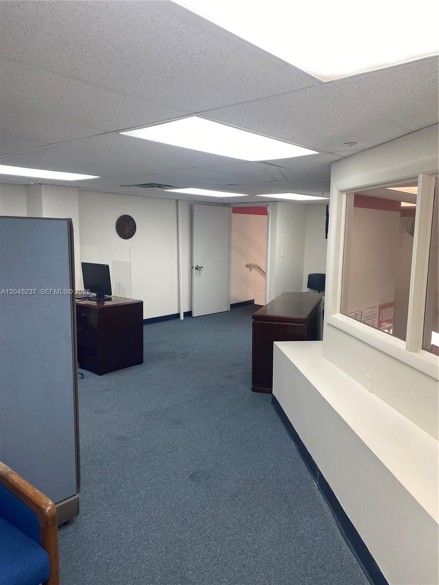 This office space features blue carpeting, drop ceilings with recessed lighting, and wooden desks — 1201 SW 8th St, Miami FL 33135, MIAMI, FL