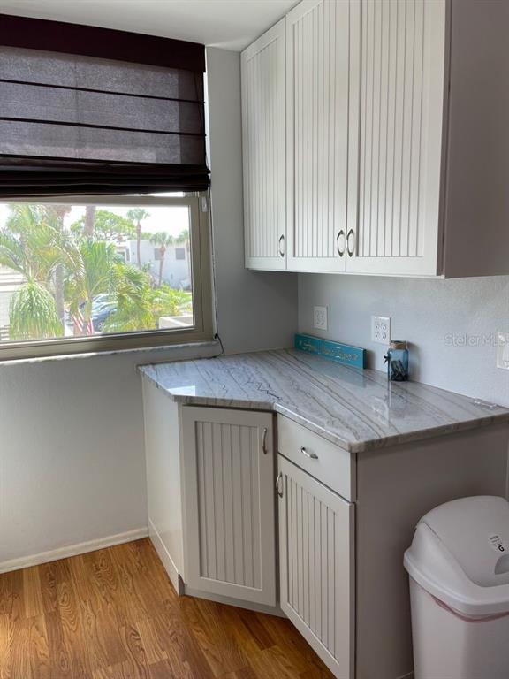A small kitchen area features white beadboard cabinets, a stone countertop, and a window view — 206 LAKEWOOD DRIVE UNIT 206, BRADENTON, FL