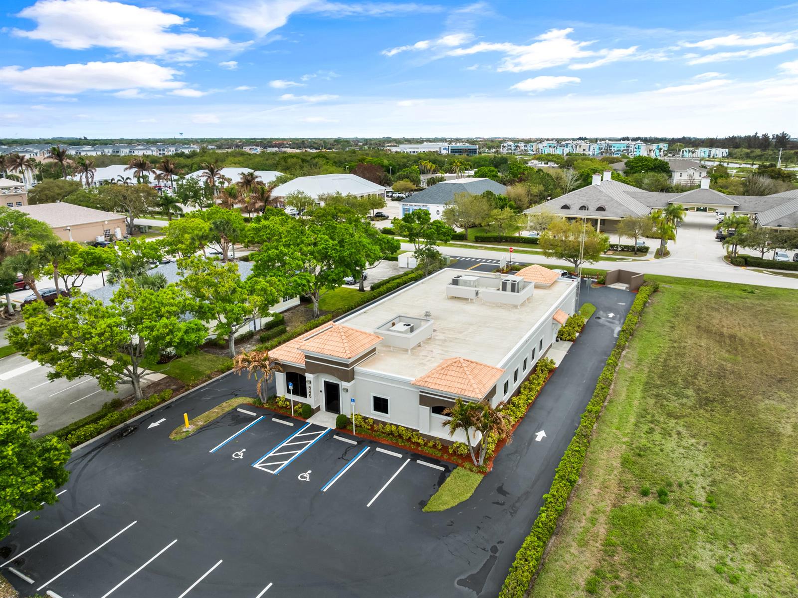 An aerial view of a single-story commercial building with a parking lot and surrounding landscaping — 845 37th Place, Vero Beach FL 32960, VERO BEACH, FL