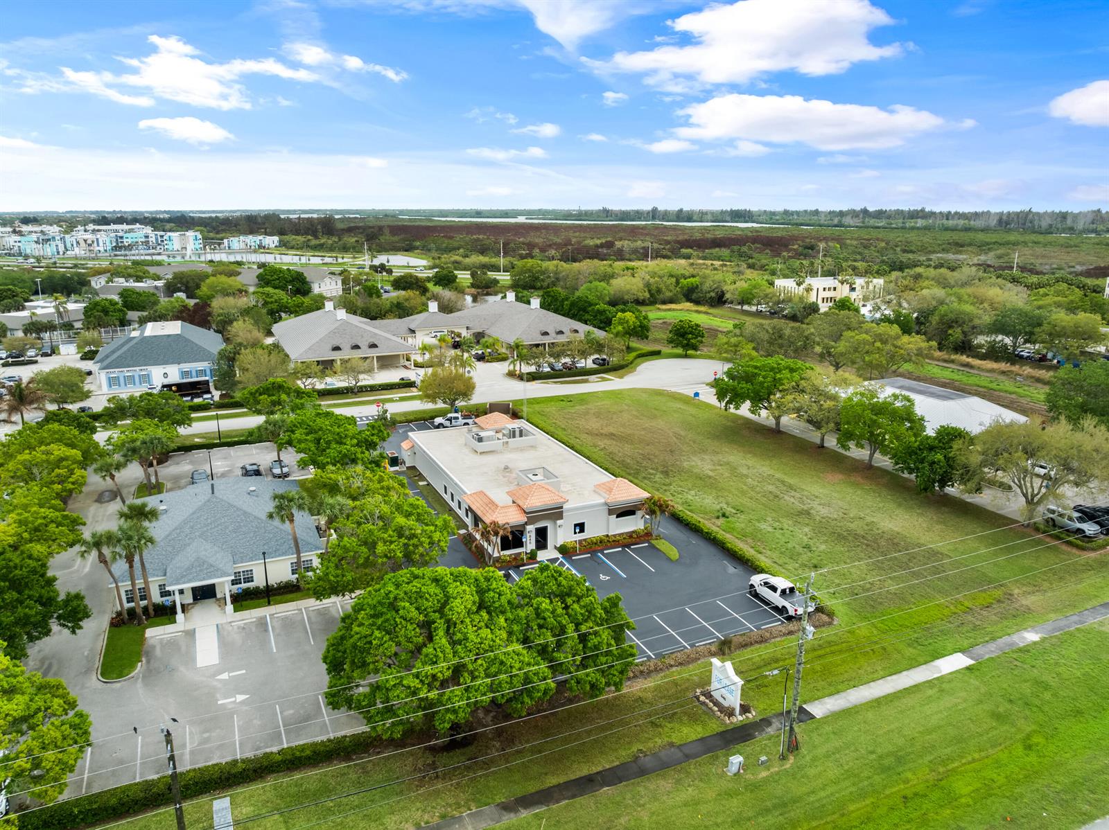 An aerial view shows two commercial buildings with parking lots surrounded by trees and grass — 845 37th Place, Vero Beach FL 32960, VERO BEACH, FL