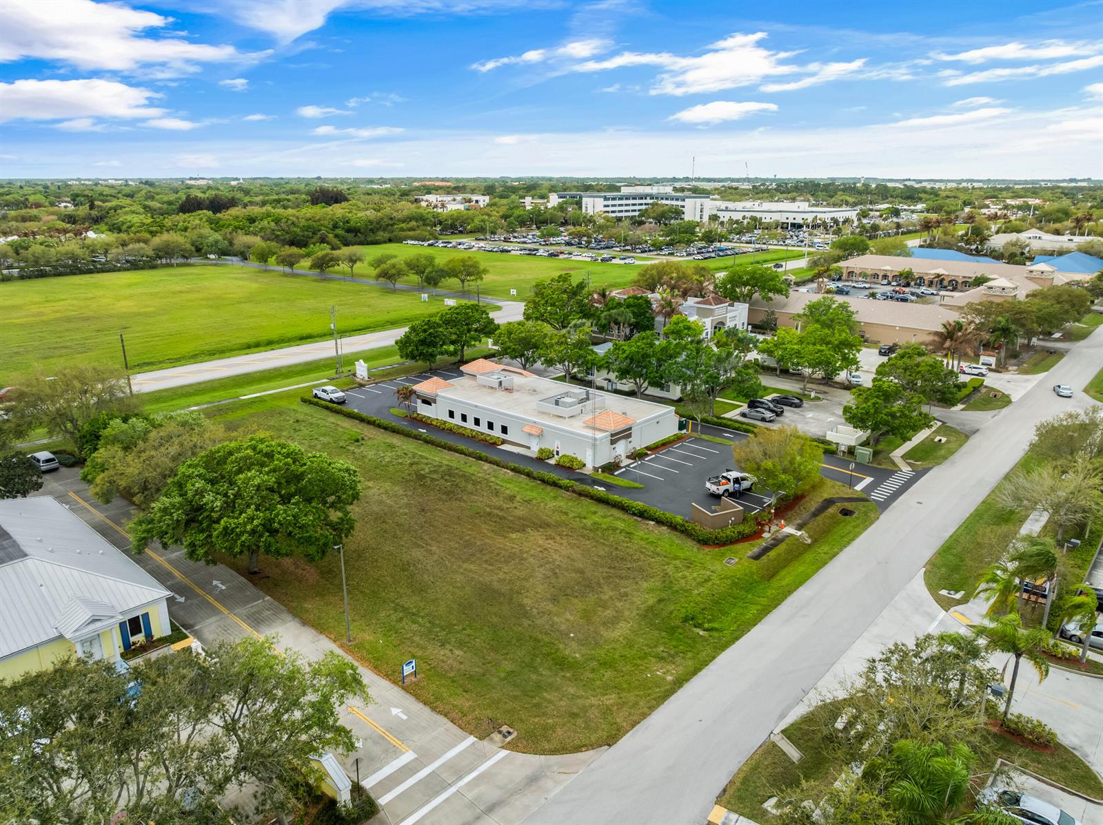 An aerial view shows a commercial building with a parking lot surrounded by green space — 845 37th Place, Vero Beach FL 32960, VERO BEACH, FL