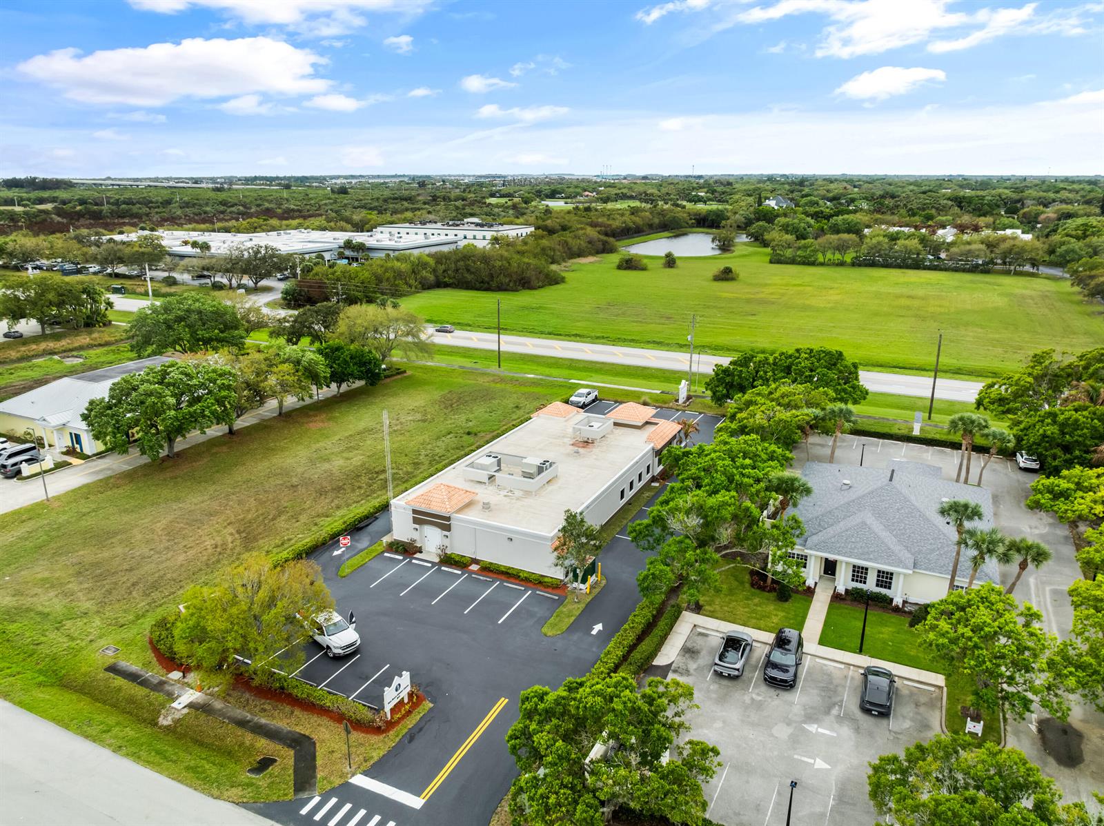 An aerial view shows two commercial buildings with parking lots surrounded by green space — 845 37th Place, Vero Beach FL 32960, VERO BEACH, FL