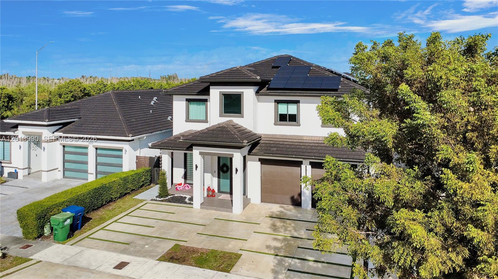 A two-story white house with a dark tiled roof, solar panels, and a concrete driveway — 14671 SW 20th St, Miami FL 33175, MIAMI, FL