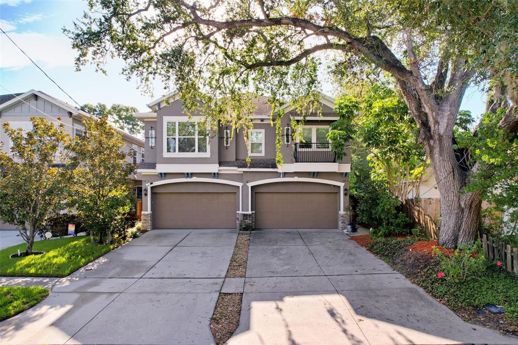 A two-story duplex with two attached garages and a large tree in the front yard — 112 S BUNGALOW PARK AVENUE UNIT 1, TAMPA, FL