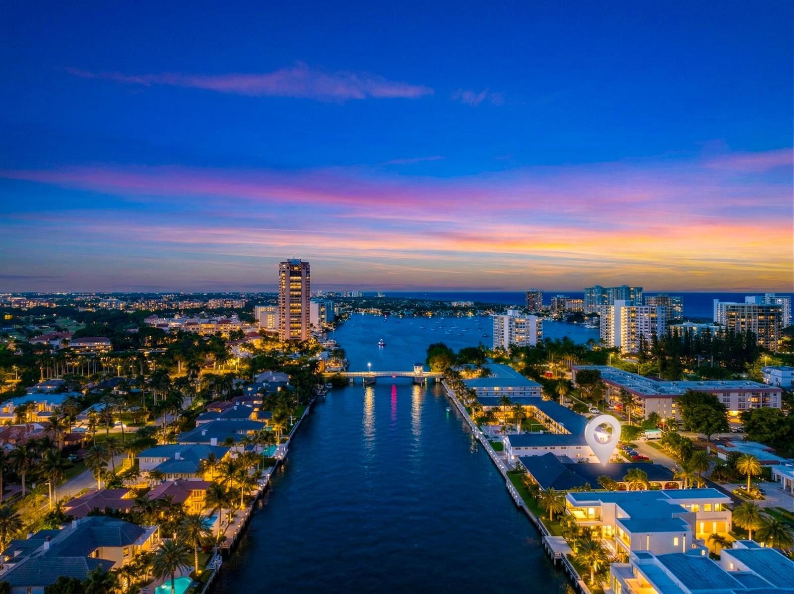 Aerial view of a waterfront residential area at dusk with a bridge and city skyline — 1075 Spanish River Road, Boca Raton FL 33432, BOCA RATON, FL