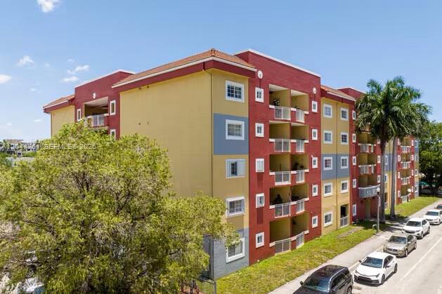 An exterior view of a multi-story apartment building with red, yellow, and blue painted walls — 21 E 3rd St # 205, Hialeah FL 33010, HIALEAH, FL