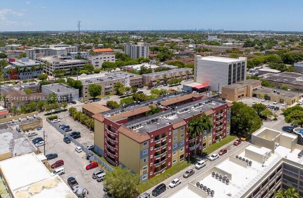 An aerial view shows a multi-story apartment complex with a parking lot and surrounding buildings — 21 E 3rd St # 205, Hialeah FL 33010, HIALEAH, FL