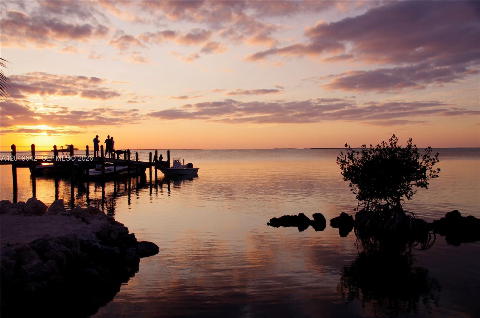 A wooden dock with people extends into the water at sunset near a small island — 8 Ocean View Blvd, Key Largo FL 33037, KEY LARGO, FL